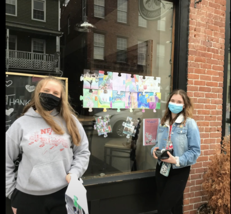 NFA students, Annika Savage and Ella Bean, stand outside one of the puzzle displays in downtown Norwich.