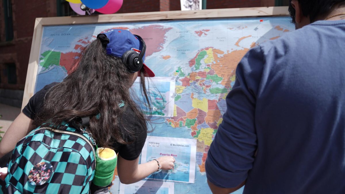 NFA students add pins to the world map, to signify their personal and familial homelands, during "NFA Across the Globe."